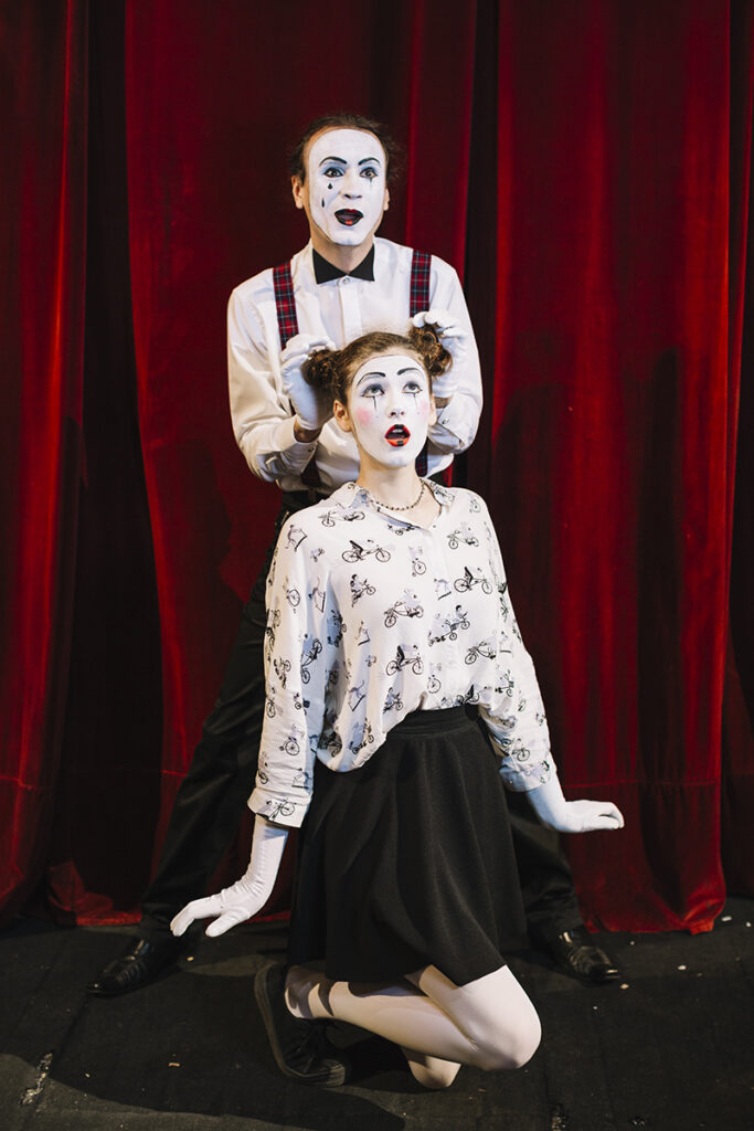artista-di-mimo-maschio-ponendo-la-mano-sui-panini-di-capelli-di-mime-femminile